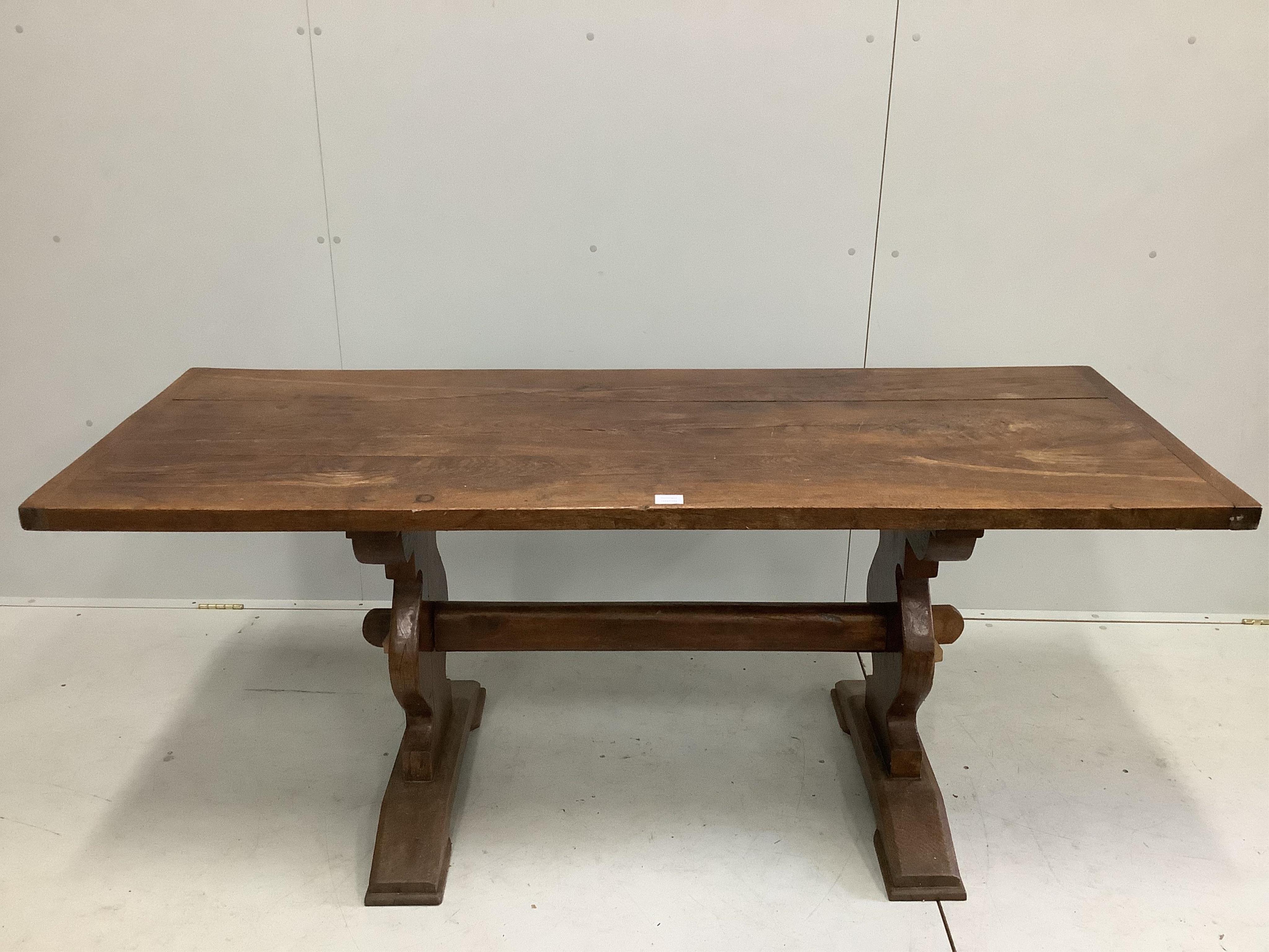 An 18th century style rectangular oak refectory dining table, on shaped end standards, width 176cm, depth 68cm, height 74cm. Condition - fair